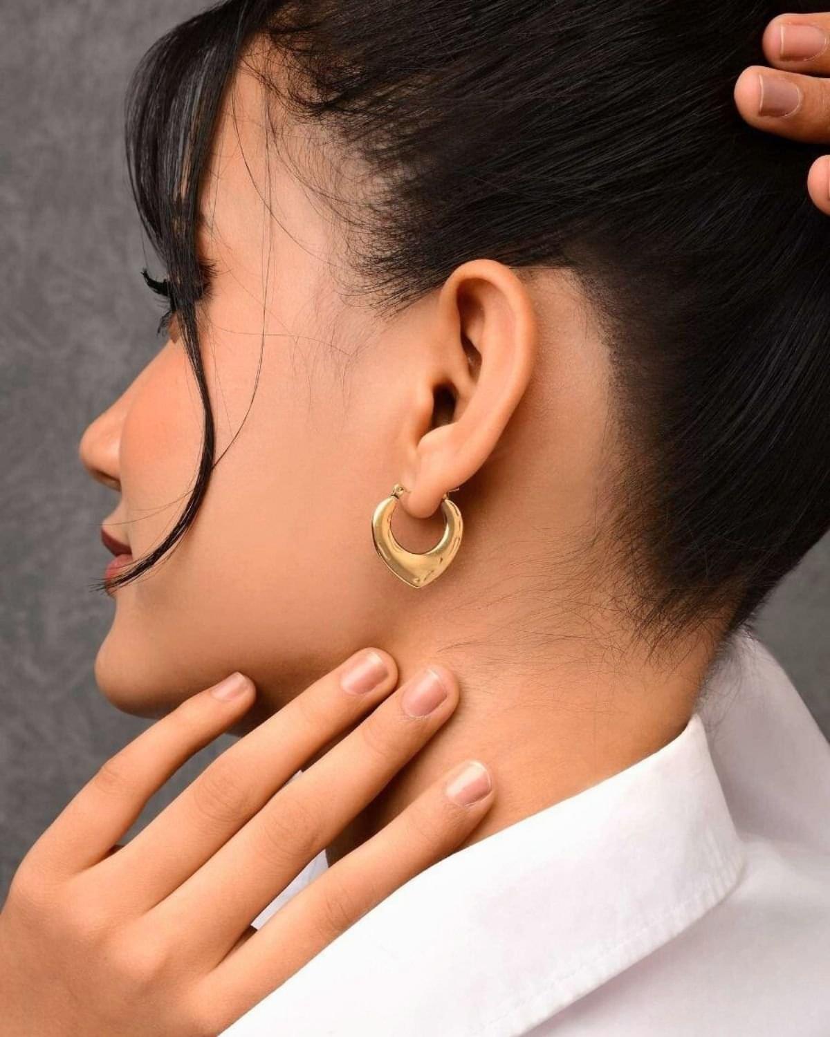 Woman with heart-shaped gold earrings